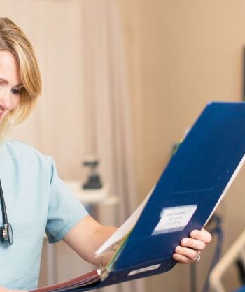 Family nurse practitioner reviewing patient chart in hospital room – how to choose a family nurse practitioner near me in 2025